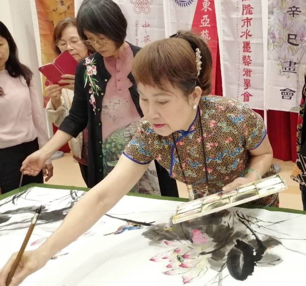 陳麗雀老師(右)於活動現場揮毫創作,備受讚譽。