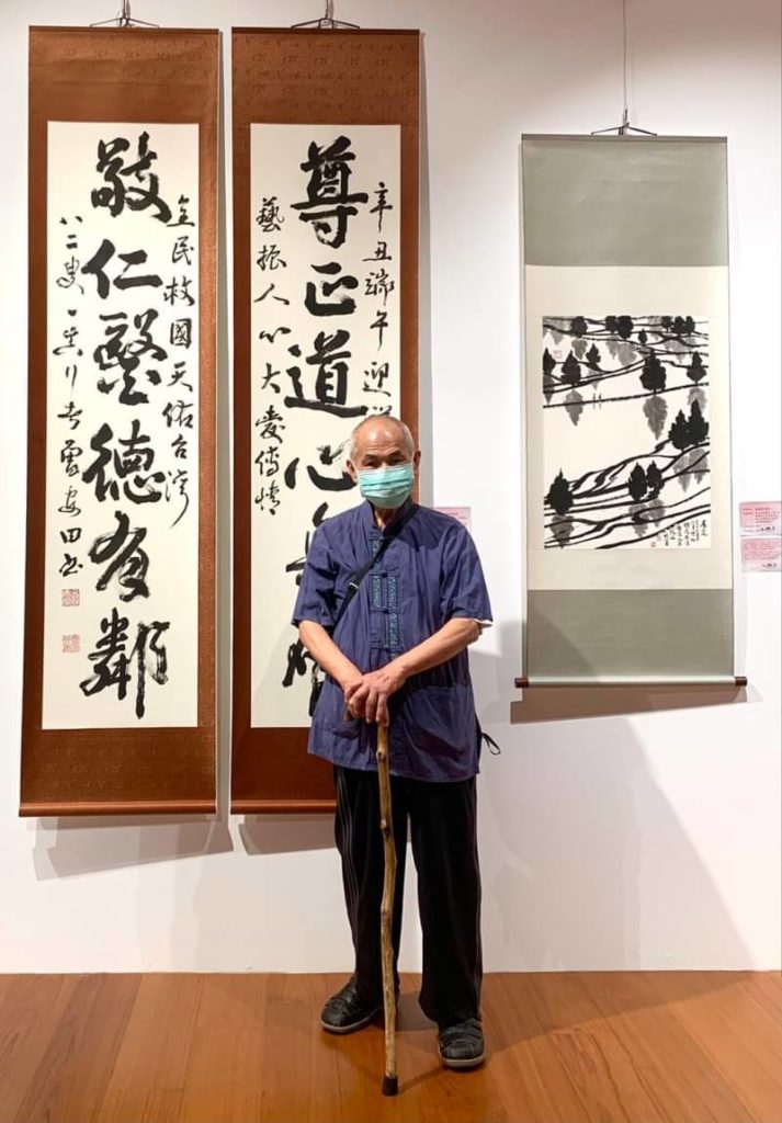知名書法家曾安田,在他的防疫書體作品前表達對防疫英雄的敬重推崇。(圖/詹美絨 攝)