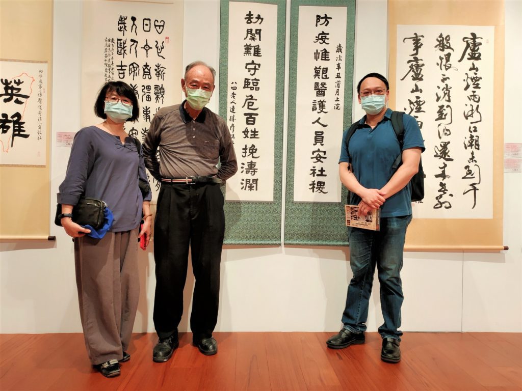 知名書法家連瑞芬理事長(左起)連勝彥大師及學界張教授展場愉悅合影,後方為連勝彥老師之防疫作品。(圖/詹美絨 攝)