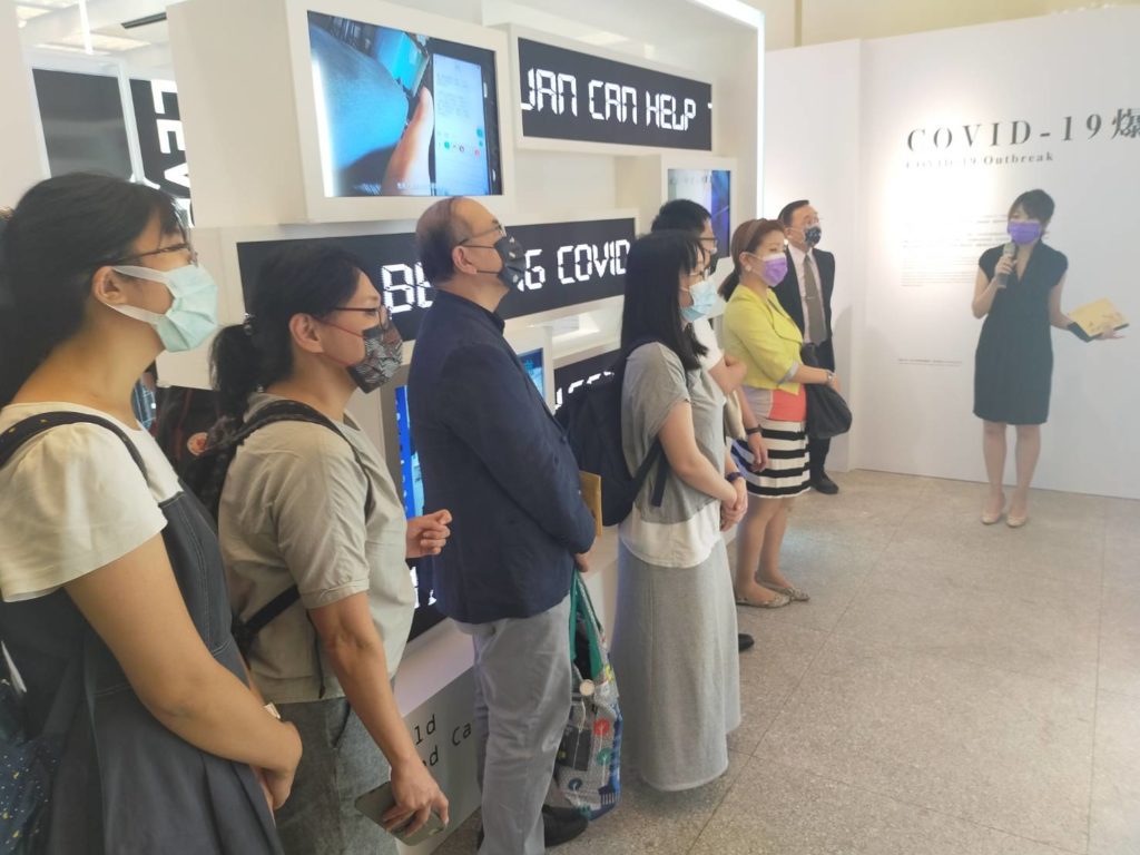 策展人洪婉喻（右一）為展出的疫情史料進行詳盡導覽。（記者 辛澎祥/攝）