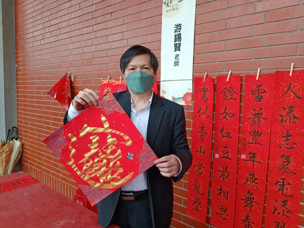 知名書法家游錫賢書寫招財進寶及傳統春聯，是全場矚目的焦點。（記者 辛澎祥/攝）