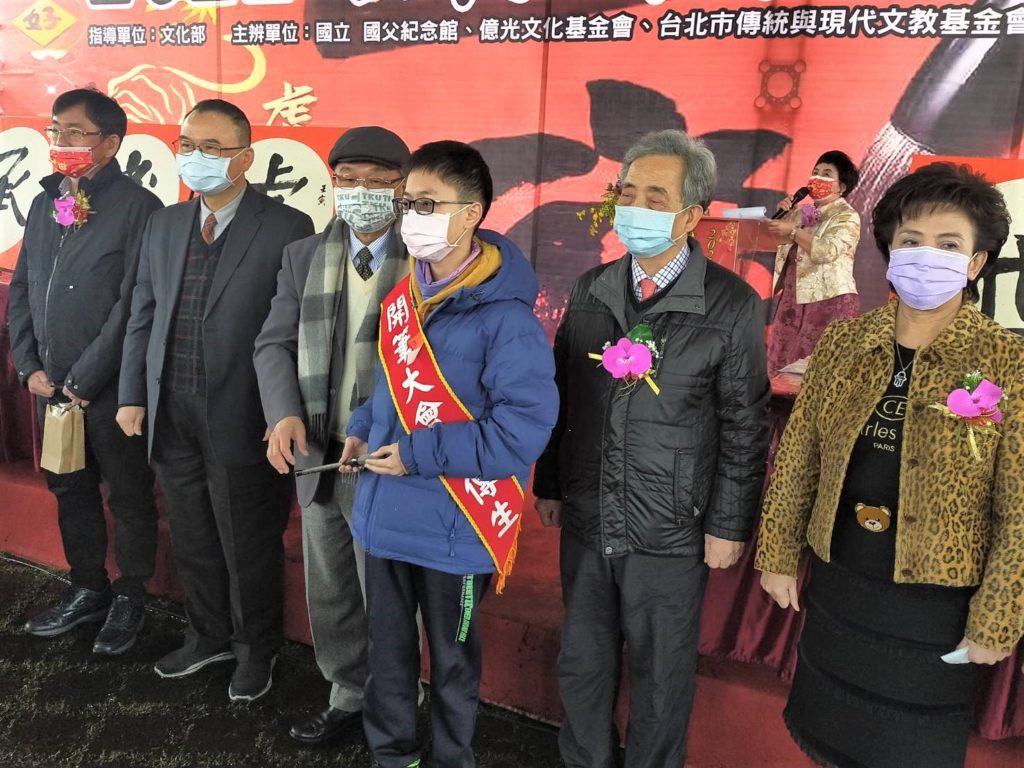 張炳煌會長(左三)將象徵傳承意義的毛筆交給書傳生代表(右三),極具活動的推廣價值。(記者 辛澎祥/攝)