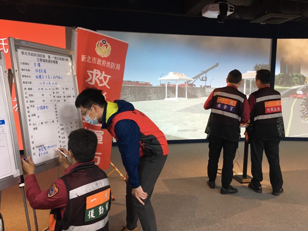 新北文化局林本源園邸園長吳俊賢(左2)於火災演練回報現場須優先搶救的文物資訊