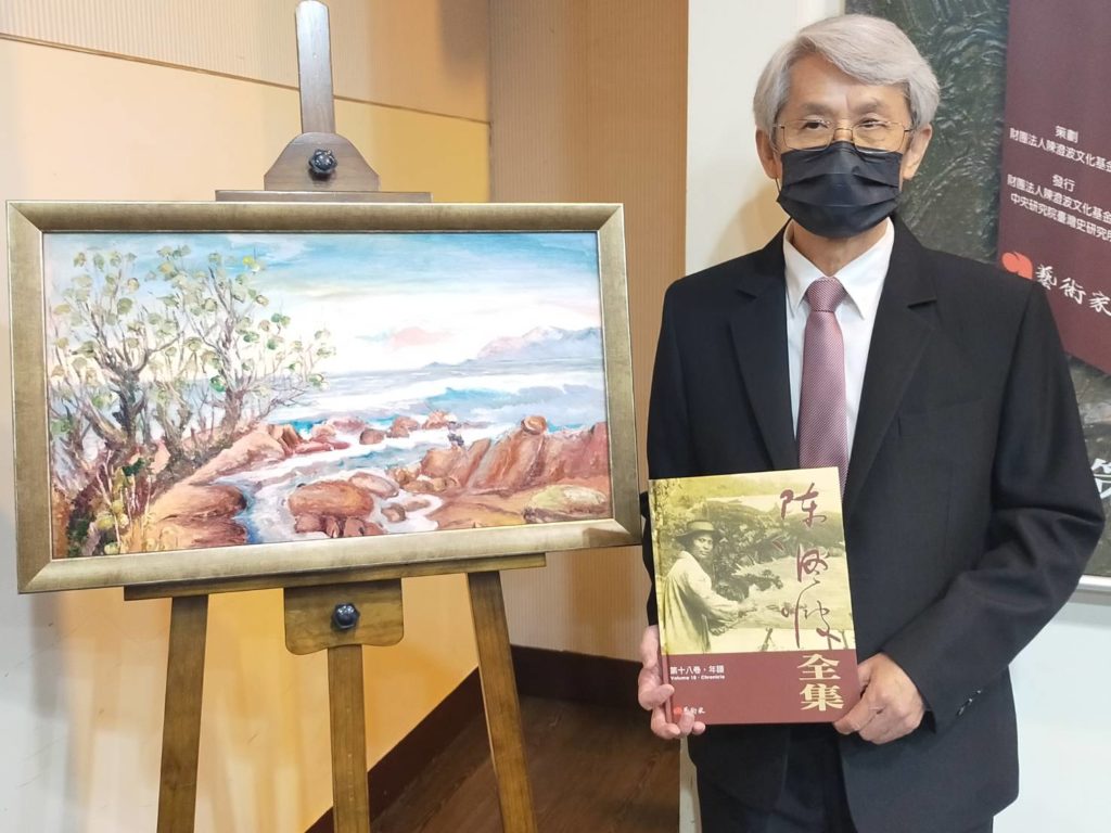 陳澄波長孫陳立栢董事長,在陳澄波畫作前拿著剛問世出版的全集,可謂悲喜交集。(記者 辛澎祥/攝)