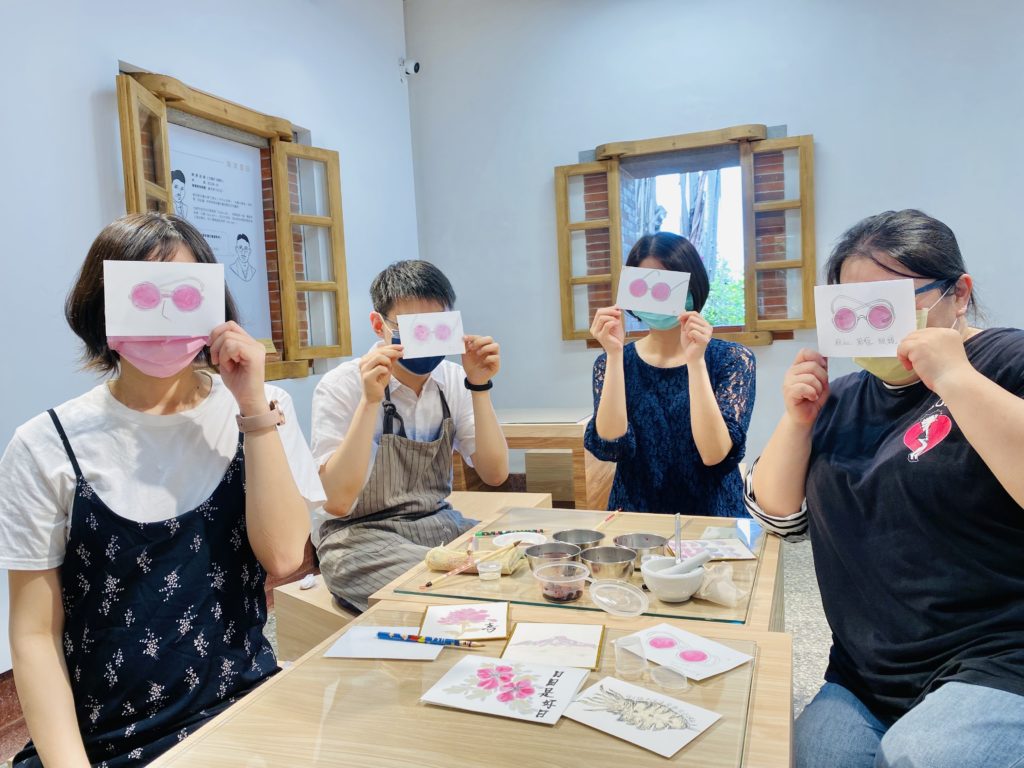 ▲淡古駐村藝術家佘心婷(右1)利用桑葚與調膠融合出粉紅色,DIY畫出木下常配戴的墨鏡款式。(圖/淡古提供)