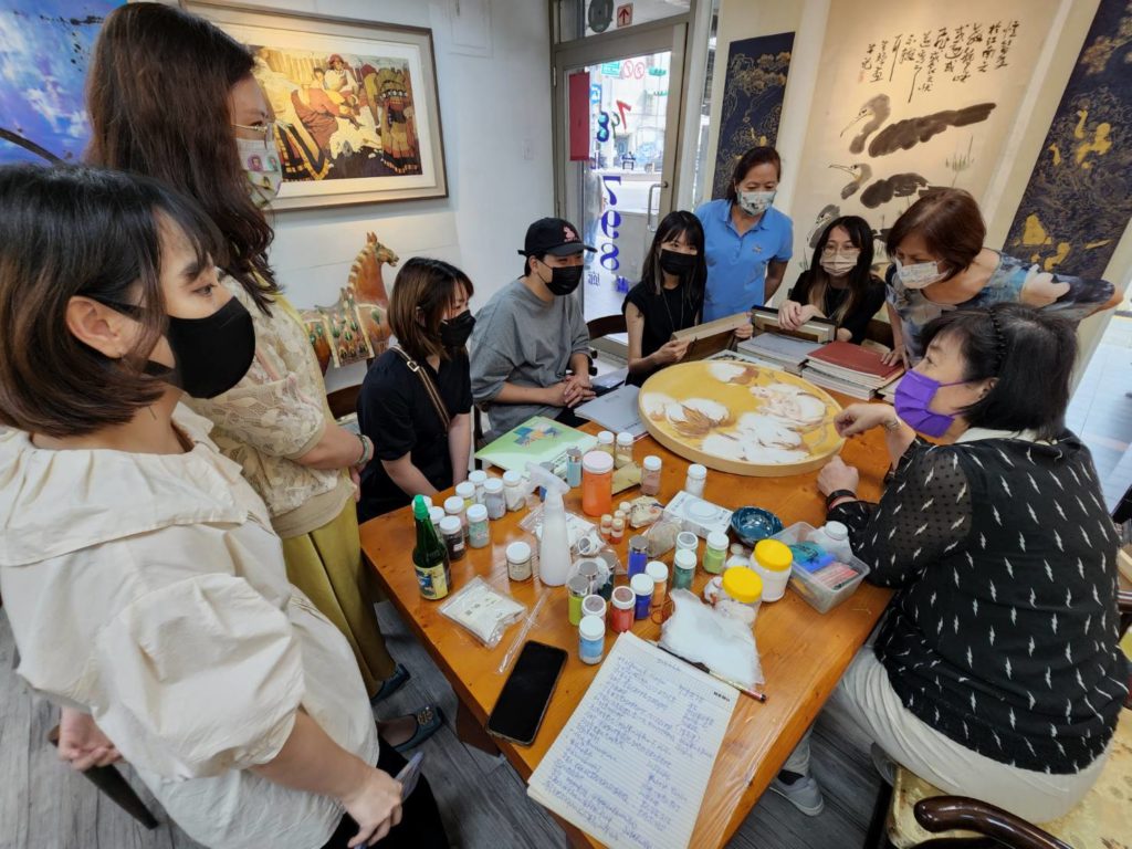 ▲陳嬋娟老師（右）對於同學所繪的膠彩畫作進行指導與經驗分享，場面熱烈。（記者 辛澎祥/攝）