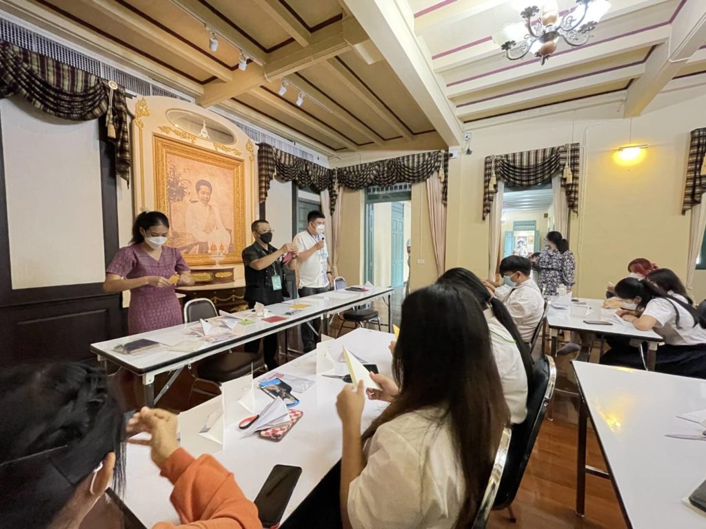 ▲洪新富老師（左中）在紙藝工作坊中，傳授紙藝創作技巧，泰國師生學習興致高昂。（圖/文化部 提供）