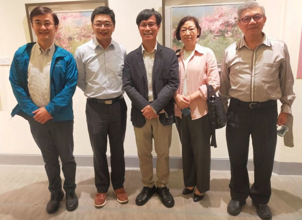 黃進龍教授(中)及夫人與多位藝術家在展場開心合影留念,右一為水墨畫家陳合成教授。(記者 辛澎祥/攝)