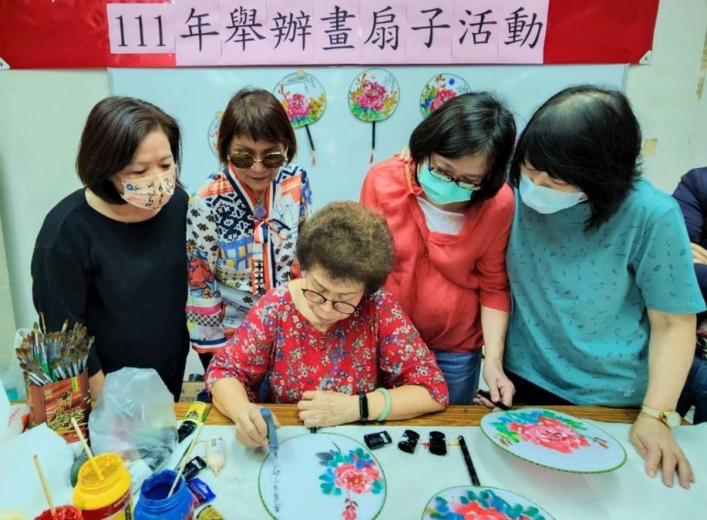 呂玉環理事長(中)在詹美絨老師(左一)及曾玉葉團長(左二)與同學們在圍繞學習中展露專注創作示範。(記者 辛澎祥/攝)