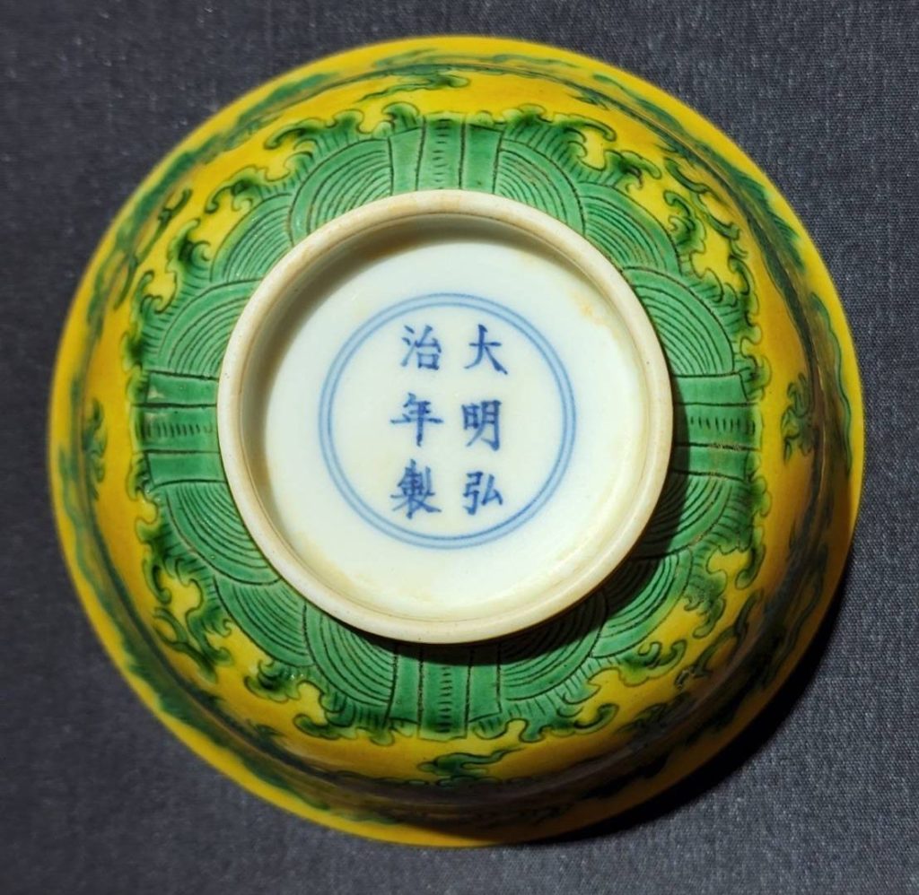 綠龍黃釉碗碗底有雙圈署以「大明弘治年製」楷體正字書寫,建構了明瓷珍品的真實呈現。(圖/曾國良 提供)