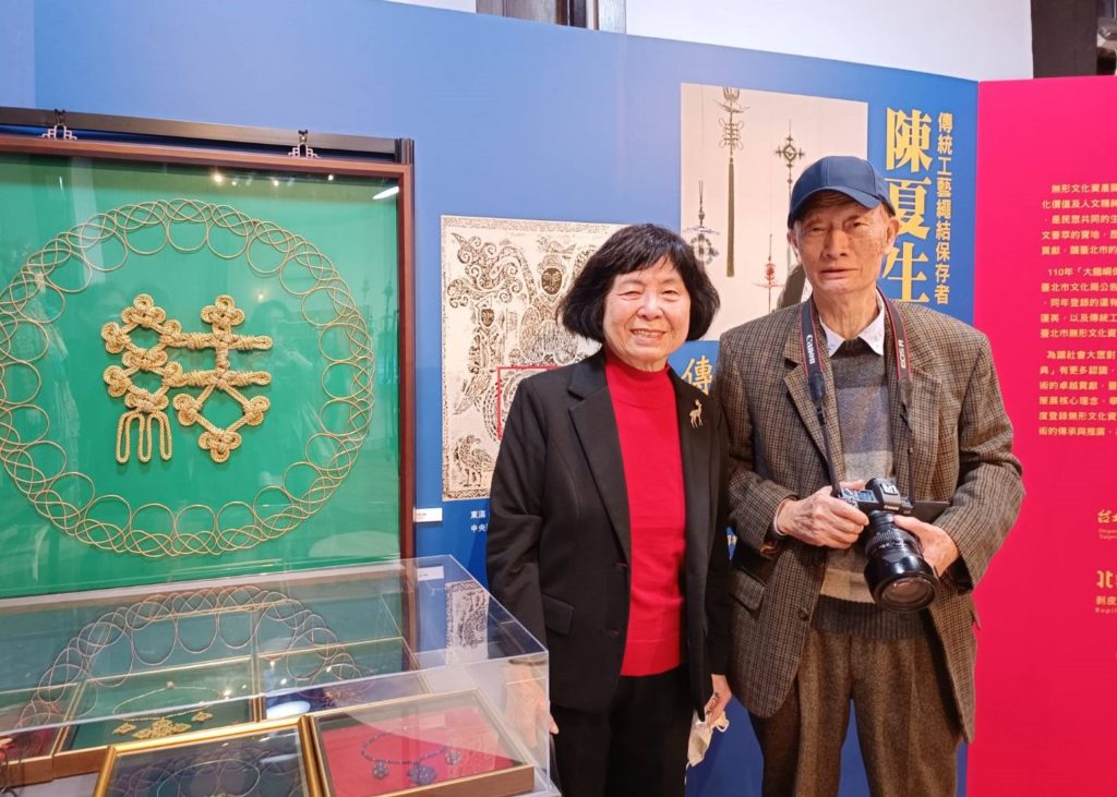 陳夏生藝師獲殊榮,夫婿攝影大師莊靈亦與有容焉,兩人於陳老師「繩結」作品前合影。(記者 陳安婷/攝)