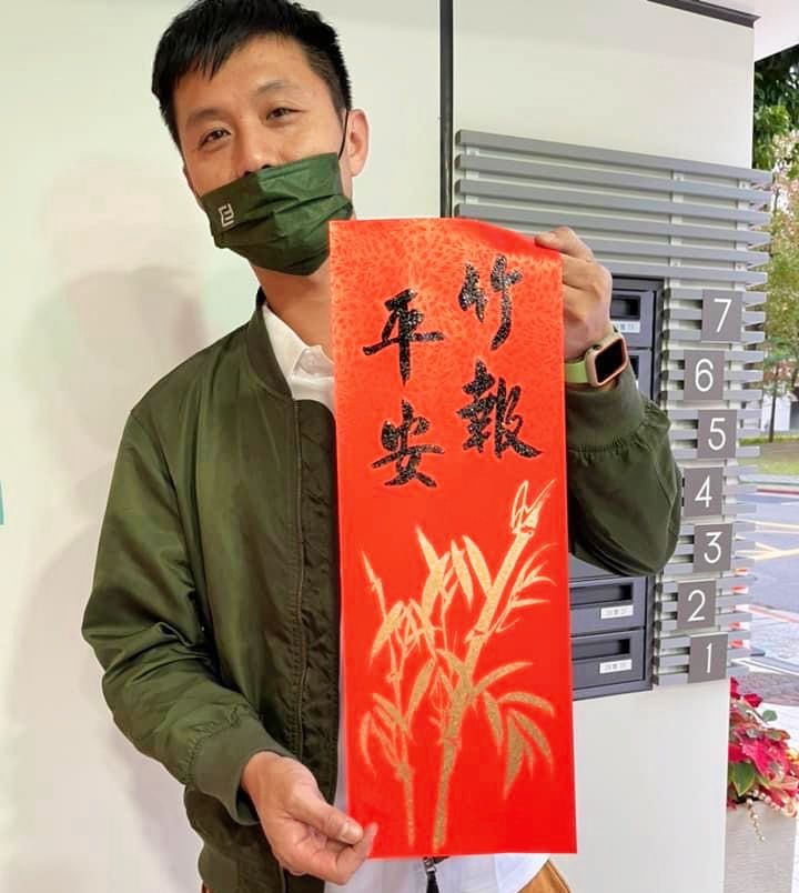 ▲宏利發建設公司員工現場拿到剛出爐的春聯,顯得相當開心。(記者 辛澎祥/攝)