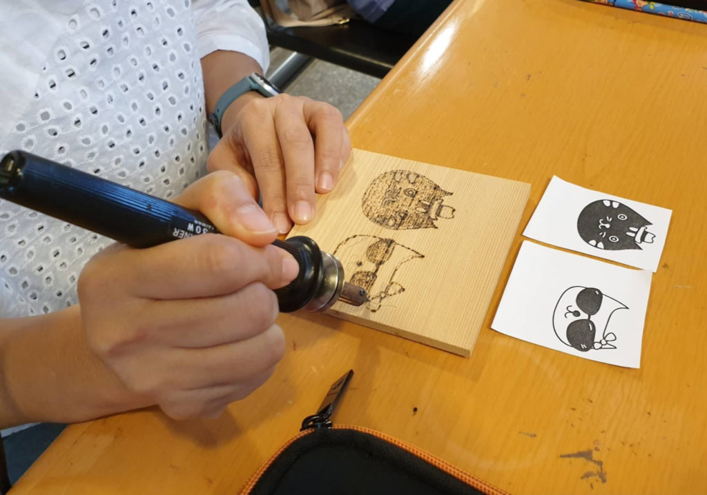 總館「原木動物繪烙畫DIY」活動引導親子在雪松上烙出喜愛的動物畫。(圖/文化局提供)
