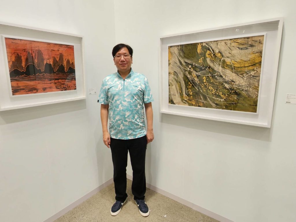 ▲藝術推廣甚力的黃河清,在他父親黃歌川的作品前細述這70年代創作的特質與心境。(記者 辛澎祥/攝)