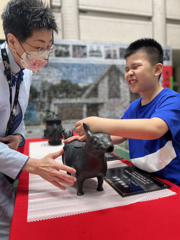 視障生觸摸複製文物「犧尊」，樂在其中。（圖/故宮提供）