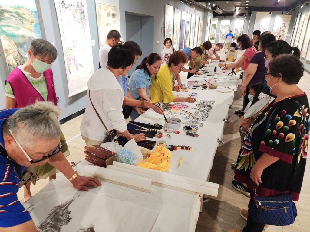 ▲參家聯展開幕式現場揮毫的書畫家老師們,在圍觀群眾的關注下,場面相當熱烈。(圖/詹佳綺 攝)