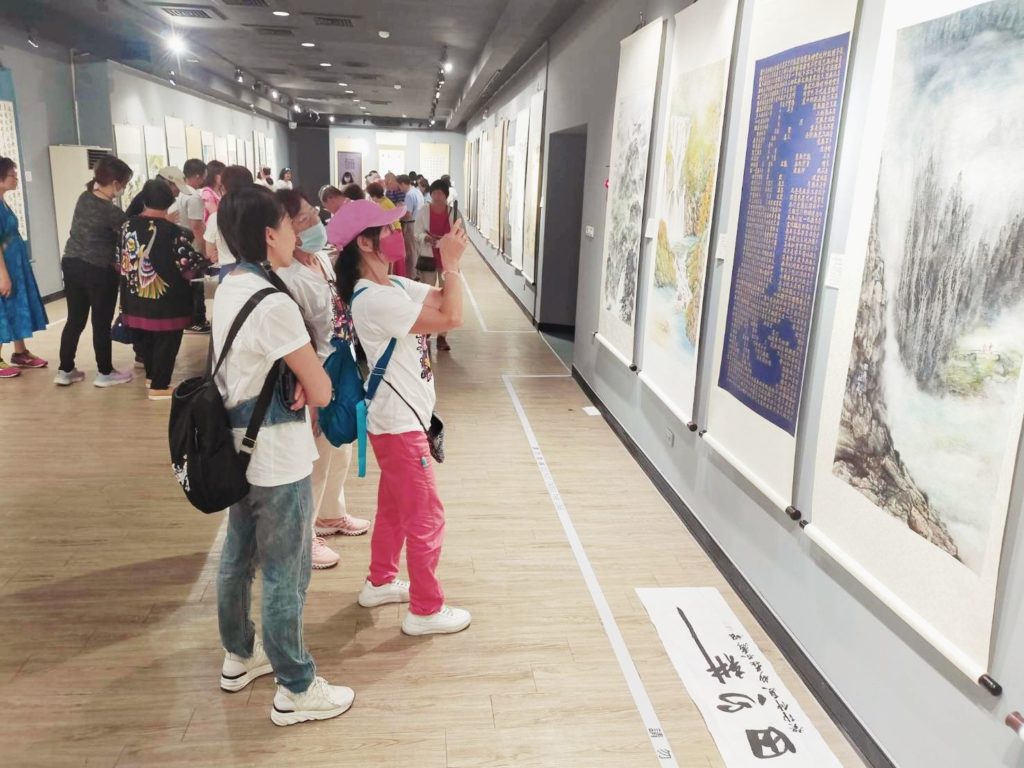 ▲民眾對金門文化局第二展覽場展出中的書畫作品感到極大興趣,紛紛拍照留念。(圖/詹佳綺 攝)