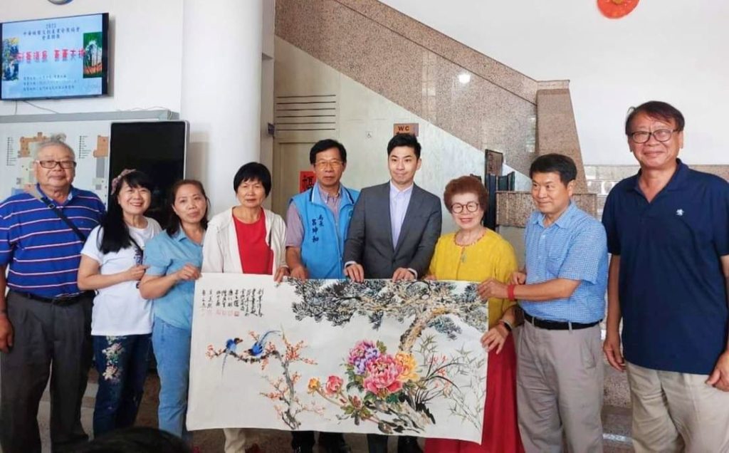 ▲知名水墨畫家呂玉環老師(右三)代表現場揮毫的老師們將完成作品贈送給金門文化局長呂坤和(左五),雙方貴賓開心合影留念。右四為行政院金馬聯合服務中心執行長楊上德。(圖/詹佳綺 攝)