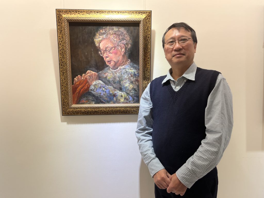 鄭心瑩以婆婆為主題的創作，先生穿著的背心是婆婆親手編織的愛心背心。(圖/雪莉攝)