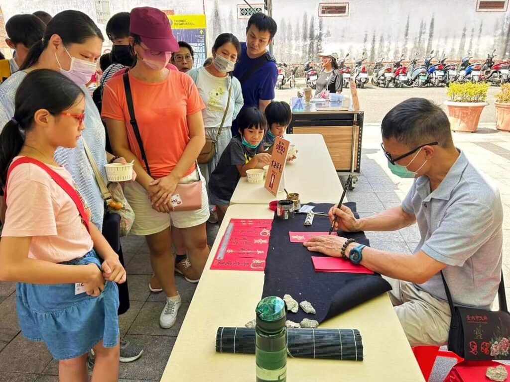 ▲書法家林加添(右)在大龍峒狀元文化節中為民眾繕寫祈福卡,相當受到歡迎。(記者 詹佳綺/攝)