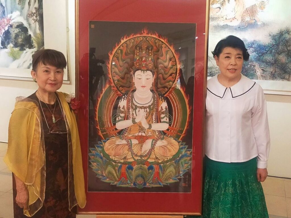 ▲陳麗雀(左)與簡文秀相互分享「大日如來」佛像畫的心境篤實與獲得,百福莊嚴中讓兩位藝術家亦具靈性之美。(記者 辛澎祥/攝)