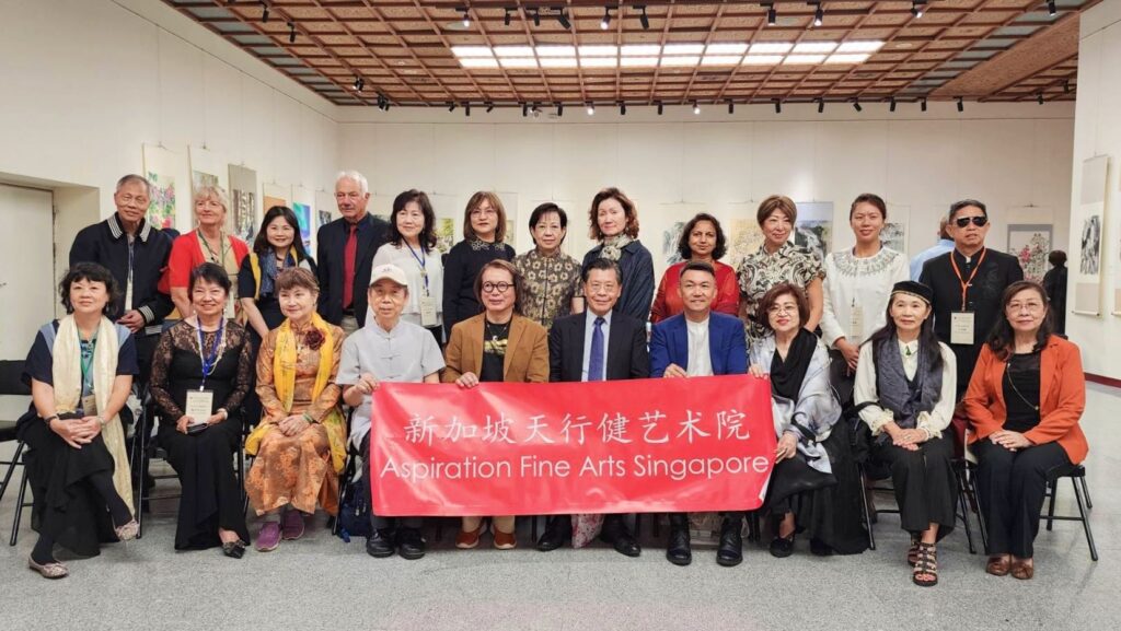 ▲來台展出的新加坡天行健藝術院一行，開幕式上在展場開心合影留念。（記者 詹佳綺/攝）