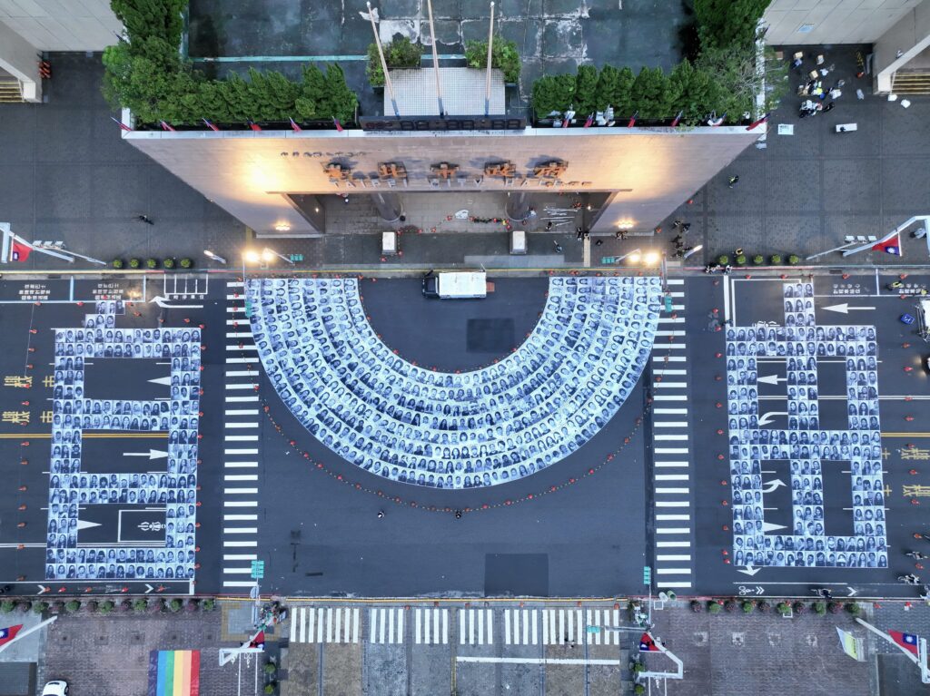 法國藝術家JR 發起的全球藝術計畫《Inside Out Project》,邀請民眾張貼鉅幅黑白照片,展示主會議題。(圖/文化局提供)