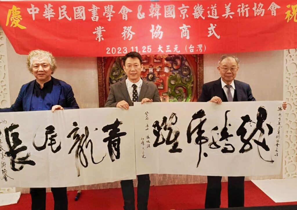 ▲兩會以揮毫書寫「青龍長尾」(淵遠流長)及「龍騰虎躍」來向與會書界人士表達祈福祝賀之意,三位書會領導人李周炯教授(左起)趙雲熙理事長及張炳煌會長,共同見證這未來交流合作歷史啟運的重要一刻。(記者 辛澎祥/攝)