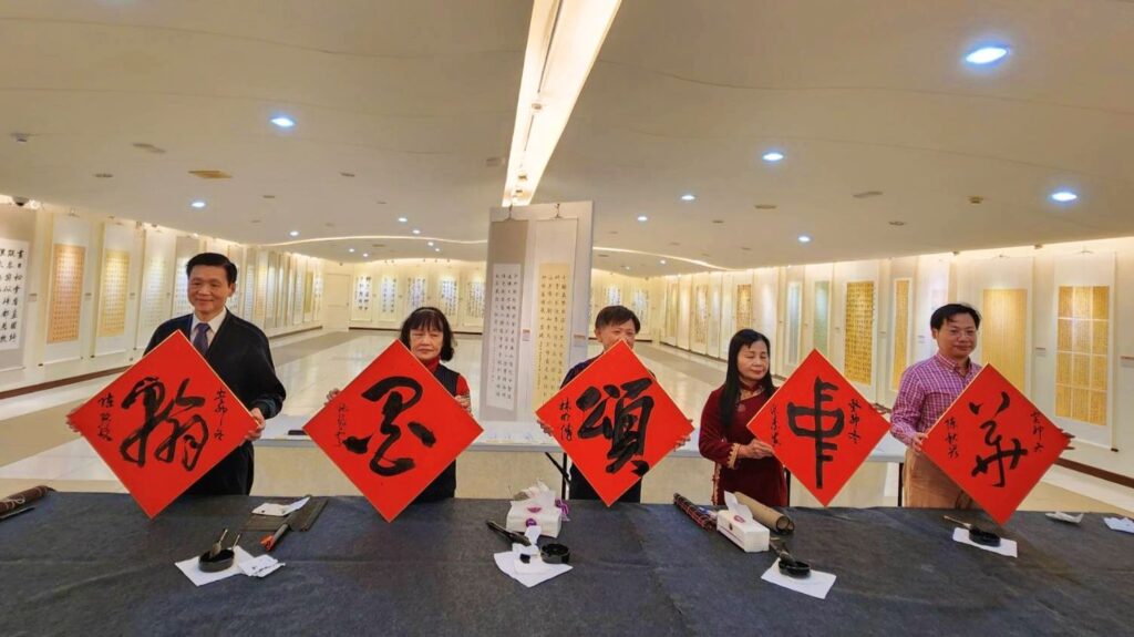 ▲主辦單位舉辦的揮毫「翰墨頌中華」的書法家分別是陳銘鏡理事長(左起)、施筱雲理事長、書法老師林明傳、監事主席陳素真與理事陳秋宏,完成後舉牌示人,備受好評。(記者 辛澎祥/攝)