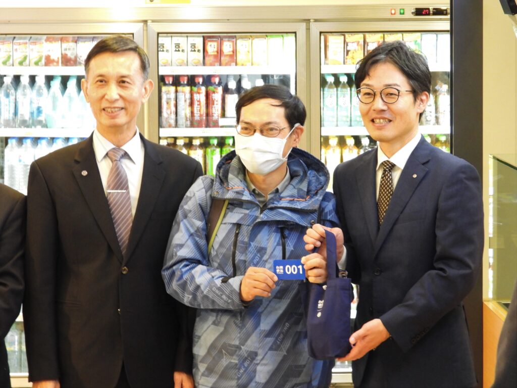 ▲搶得頭香的第一位排隊買到便當的旅客（中）開心與臺日鐵路高層合影留念。（圖/臺鐵 提供）
