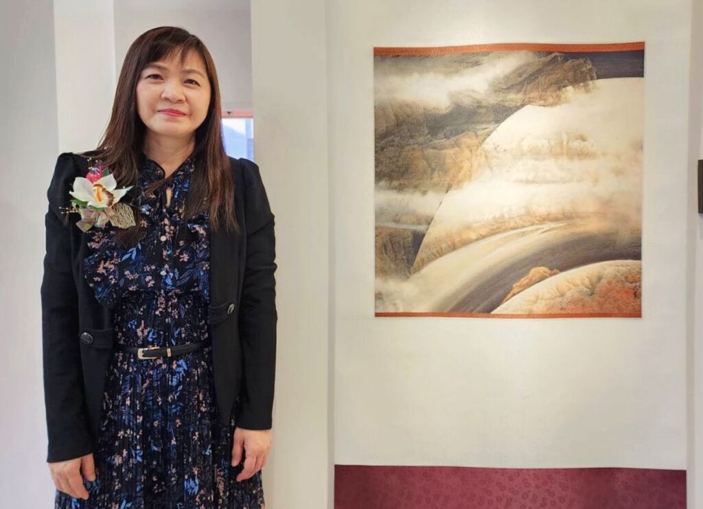 ▲楊企霞老師在作品「時空旅程」前留影,並強調以時空意象馳騁在超現實的虛無幻化中,追求心境的篤實與平靜。(記者 辛澎祥/攝)