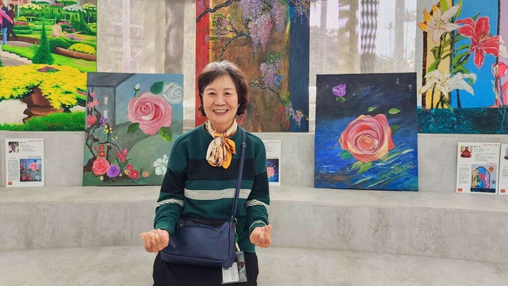 ▲資深油畫家劉玉燕在其展出作品前留影，顯得神情相當愉快。（記者 辛澎祥/攝）