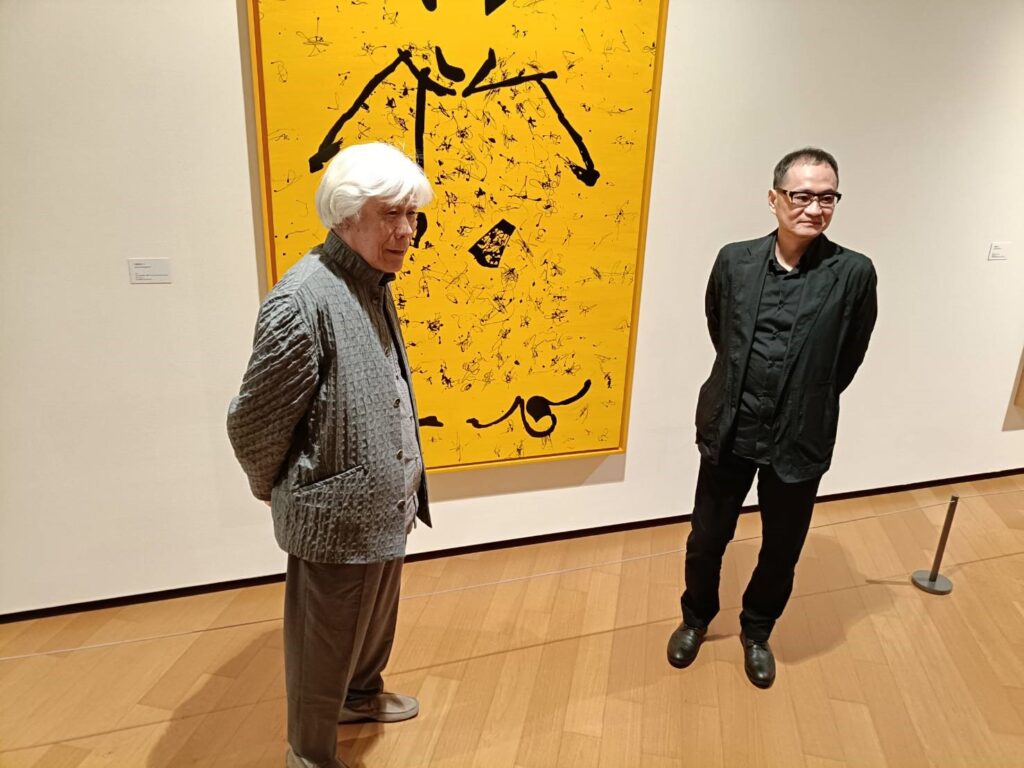 王懷慶大師(左)與本展策展人王嘉驥於「中國皇帝」系列作品前互動合影,流露真情。(記者 陳安婷/攝)