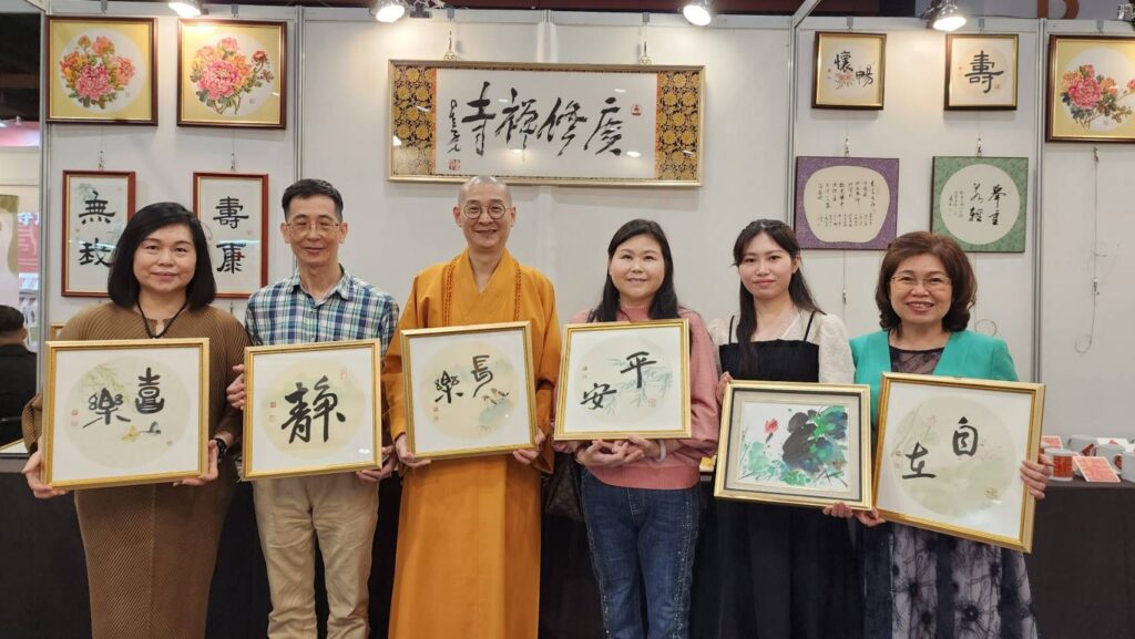 ▲大慧法師（左三）與前來活動現場購買他所寫的書法作品的貴賓開心合影留念。（記者 辛澎祥/攝）