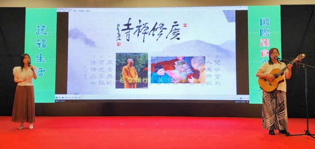 ▲兩位影片中的演唱歌手，上台現場演唱及背景放影片(介紹廣修+整年師父弘法行脚活動)，讓現場觀眾為之動容。（記者 辛澎祥/攝）