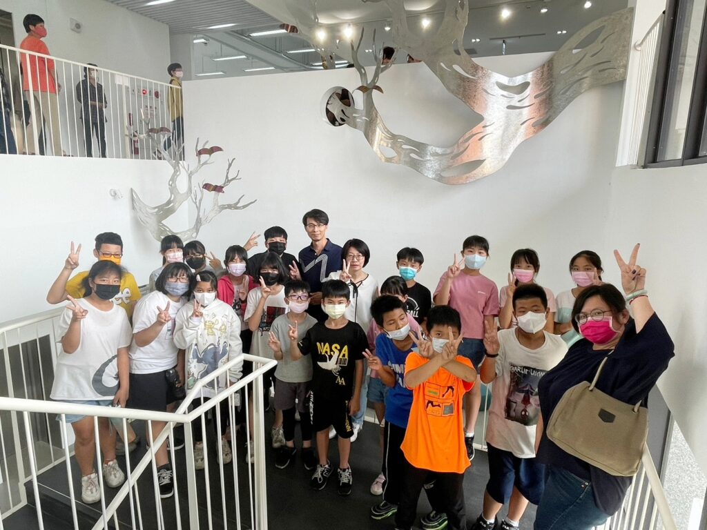 藝術家郭國相與小朋友在公共藝術品「育樹臨楓」合影 。（圖/文化局提供）