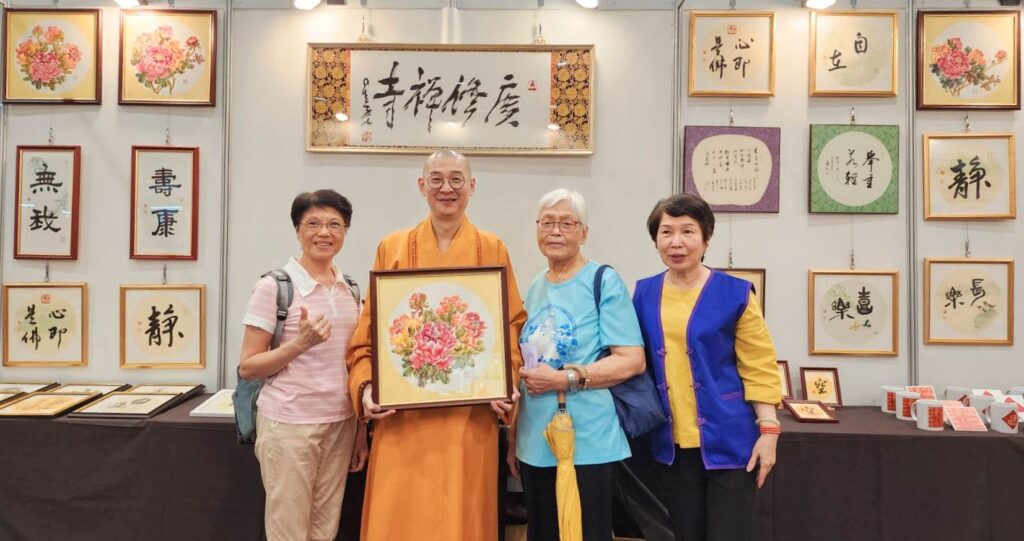 ▲由知名水墨畫家呂玉環所繪製的牡丹系列畫作，極具藝術價值並受到民眾熱烈的購藏，並由大慧法師（左二）與買方（左一）合影留念。（記者 辛澎祥/攝）