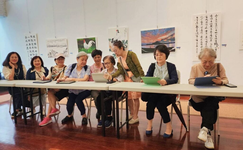 ▲彩墨畫家蔡愛珠（中立者）與多位體驗e筆創作的書畫界人士互動密切。（記者 辛澎祥/攝）