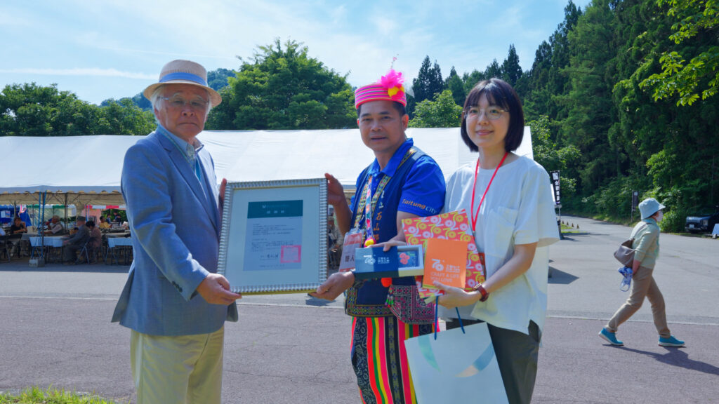 有限責任台東縣東海岸原住民社區合作社的林宋博芳理事主席代表工藝中心致贈感謝狀予日本福島縣三島町矢澤源成町長，並進行臺灣原住民祈福祝禱儀式。（圖/工藝中心提供）