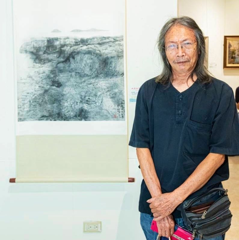 ▲澎湖參展藝術家洪根深教授,在他的作品前留影,以不同的媒材及表現手法,將澎湖的山海景致具體呈現。(圖/大媒體新聞網 提供)
