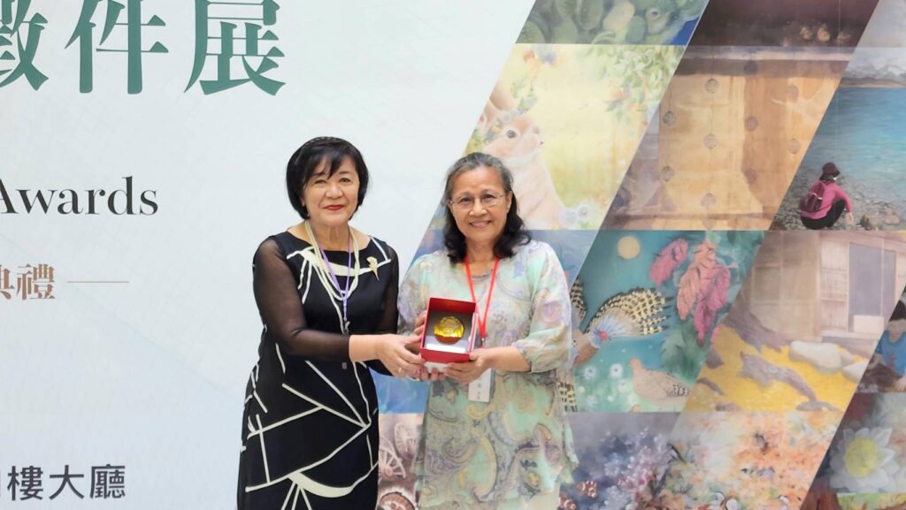 ▲台灣綠水畫會理事長陳嬋娟(左)代表畫會贈送紀念禮品以表達對甫卸任現為畫會榮譽理事長楊玉梅的感謝之忱。(記者 辛澎祥/攝)