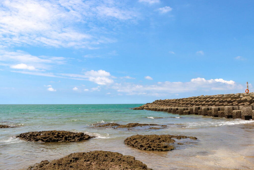 ▲三芝區淺水灣擁有彎月形沙灘的海濱美景，海岸線具有岩岸與沙灣的特質。（圖/新北觀旅局 提供）