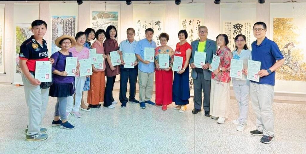 ▲協會參展藝術家在澎湖展場開心合影留念，場面熱烈。（記者 辛澎祥/攝）
