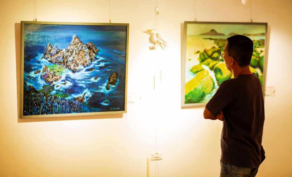 ▲民眾觀賞展出作品相當入神,也能體會山海景致描繪的質感與意象。(記者 辛澎祥/攝)