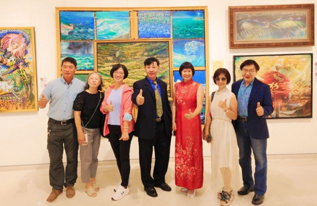▲知名油畫家陳國強老師(中)與學生們以「聽海之音」為主題的大壁面燒蠟畫與油畫的拼接創作,顯得壯觀且創意十足。(記者 辛澎祥/攝)