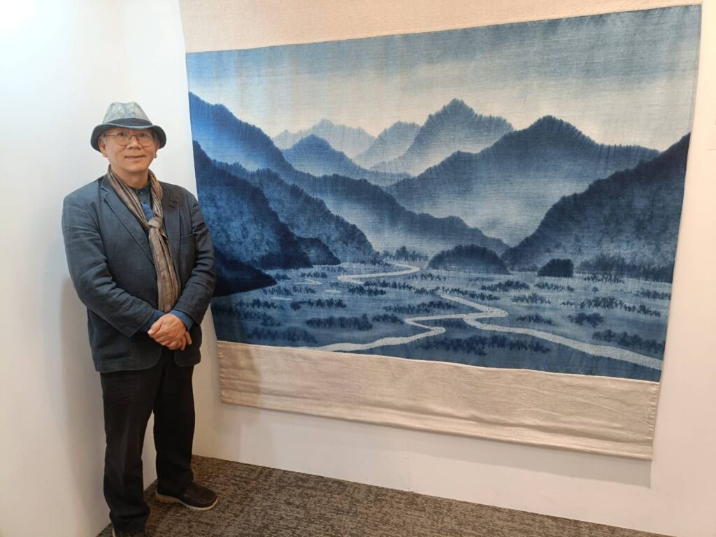 ▲獲得國家工藝成就獎的染織藝師陳景林,在他所創作的作品前做導覽,令觀者十分愉悅有情。(記者 辛澎祥/攝)