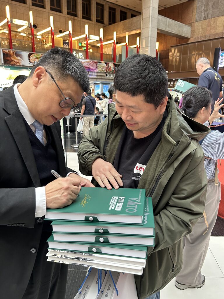 ▲臺鐵公司董事長杜微（左）為鐵道迷簽書紀念。（圖/臺鐵公司 提供）