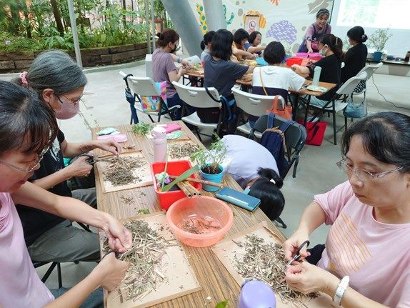 民眾認真製作「青草按摩槌」。（圖/台北市公園處提供）