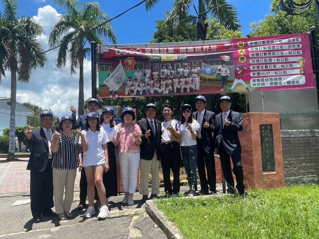 ▲新豐國小棒球隊代表臺灣前往日本比賽前,與會貴賓在校門口的巨幅海報前合影留念。(圖/楊淵文慈善基金會 提供)