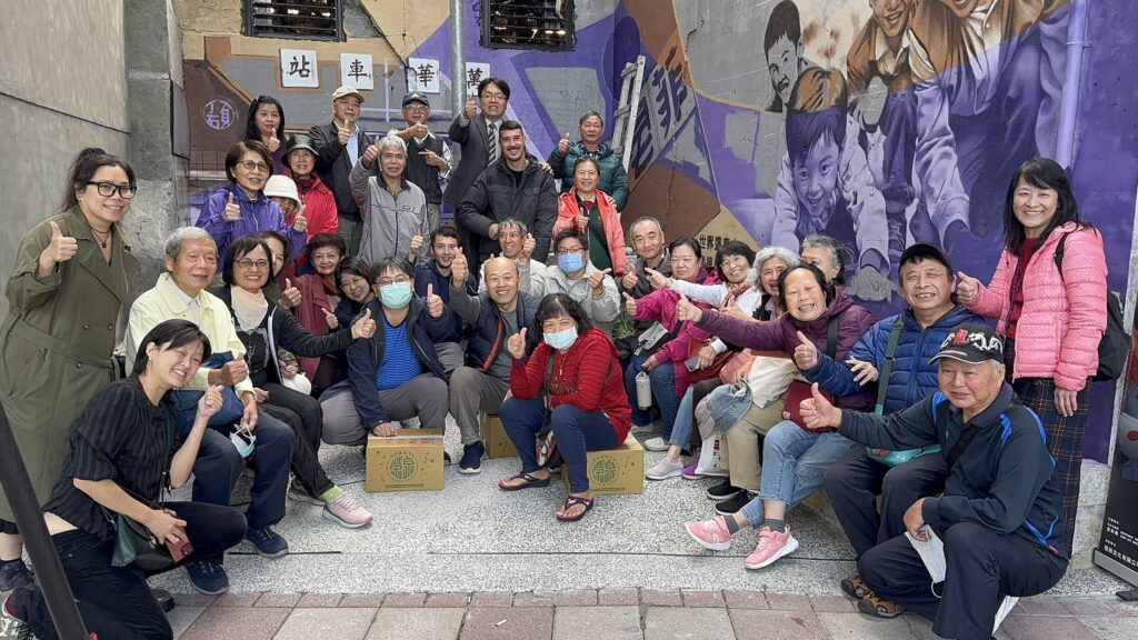 荷蘭與比利時街頭塗鴉藝術家ENOFone，里長與社區民眾齊聚萬華區頂碩里，透過豐富色彩與噴漆技法，為老舊牆面注入全新生命力。（圖/台北市政府青年局提供）